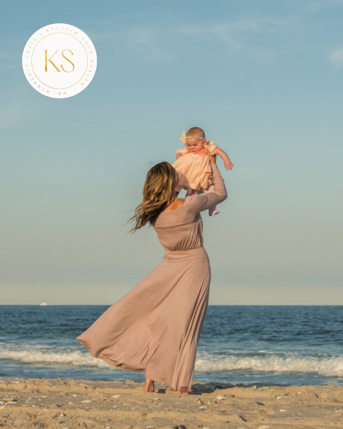 Dr. Kimberly holding her baby at the beach.