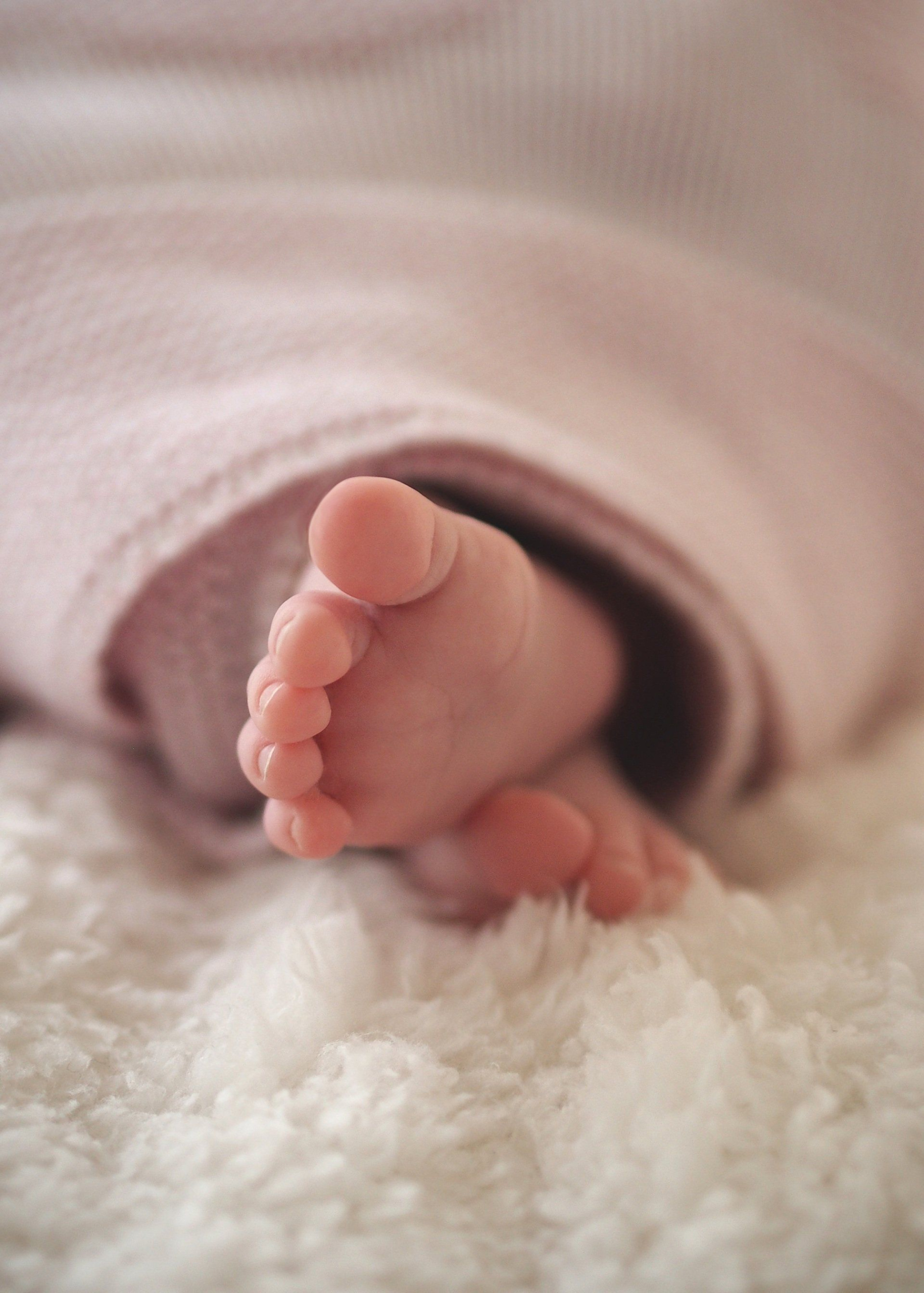 Baby feet sticking out of a warm blanket.