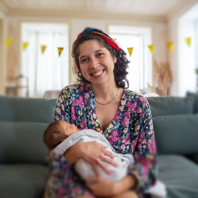 A happy mom holding her newborn baby.