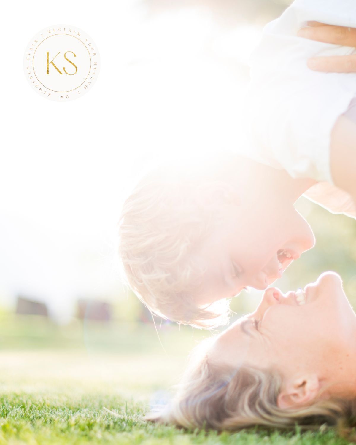 Empowered moms: a mom and her young child laughing and playing in the grass.