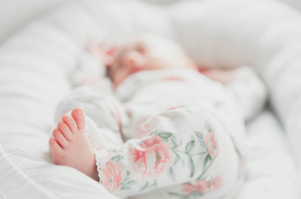 Baby sleeping peacefully in its crib with a Somavedic device in the room.