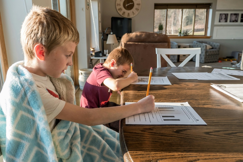 Two young kids focused on their homework with Somavedic's help.